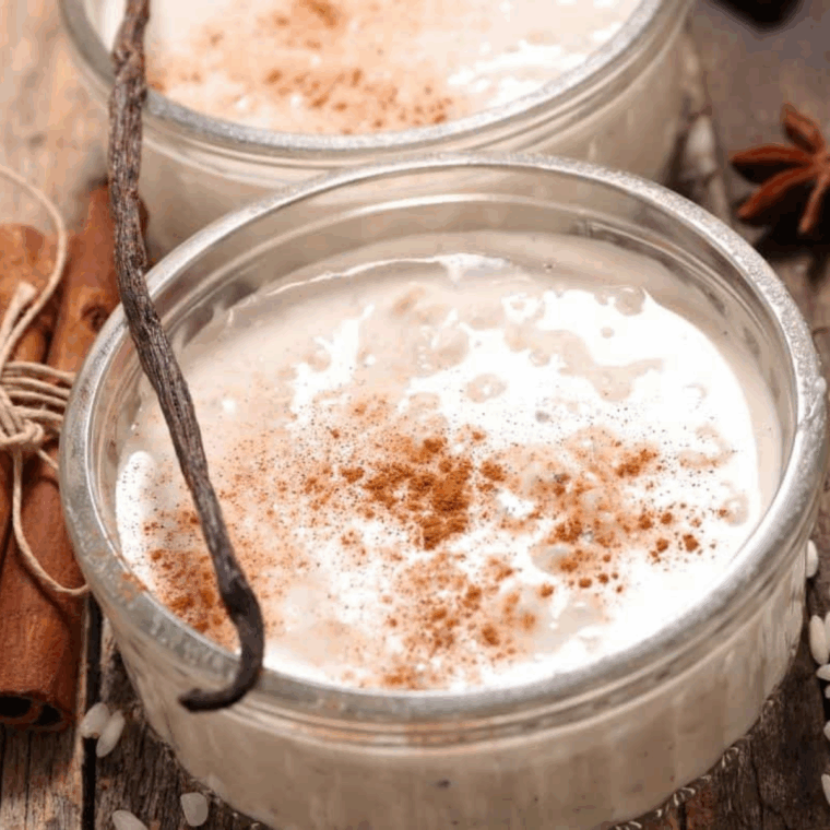 Serve: Creamy rice pudding served in bowls, garnished with cinnamon and nutmeg