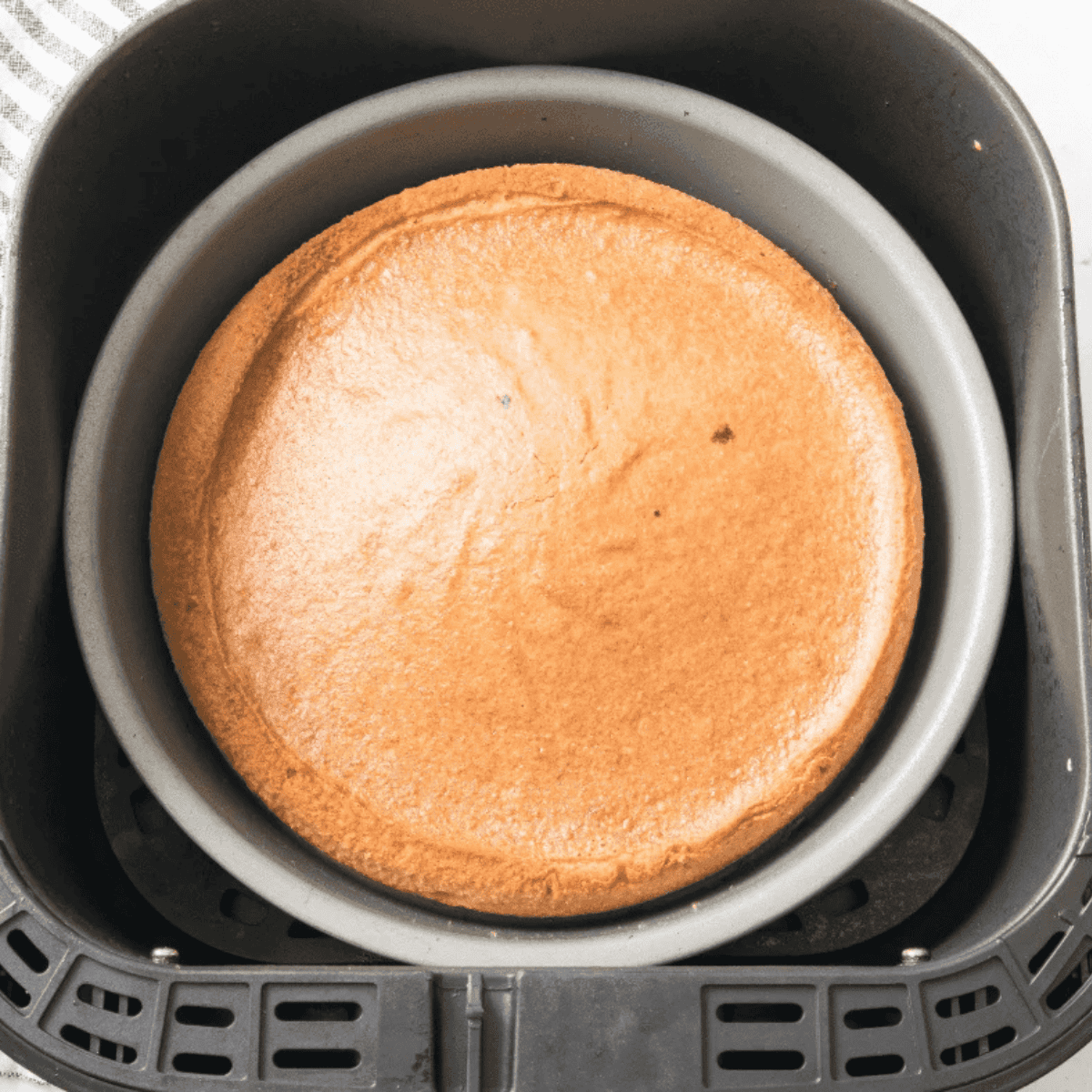 Golden, moist Air Fryer Vanilla Cake cooling on a wire rack, ready to serve or frost.