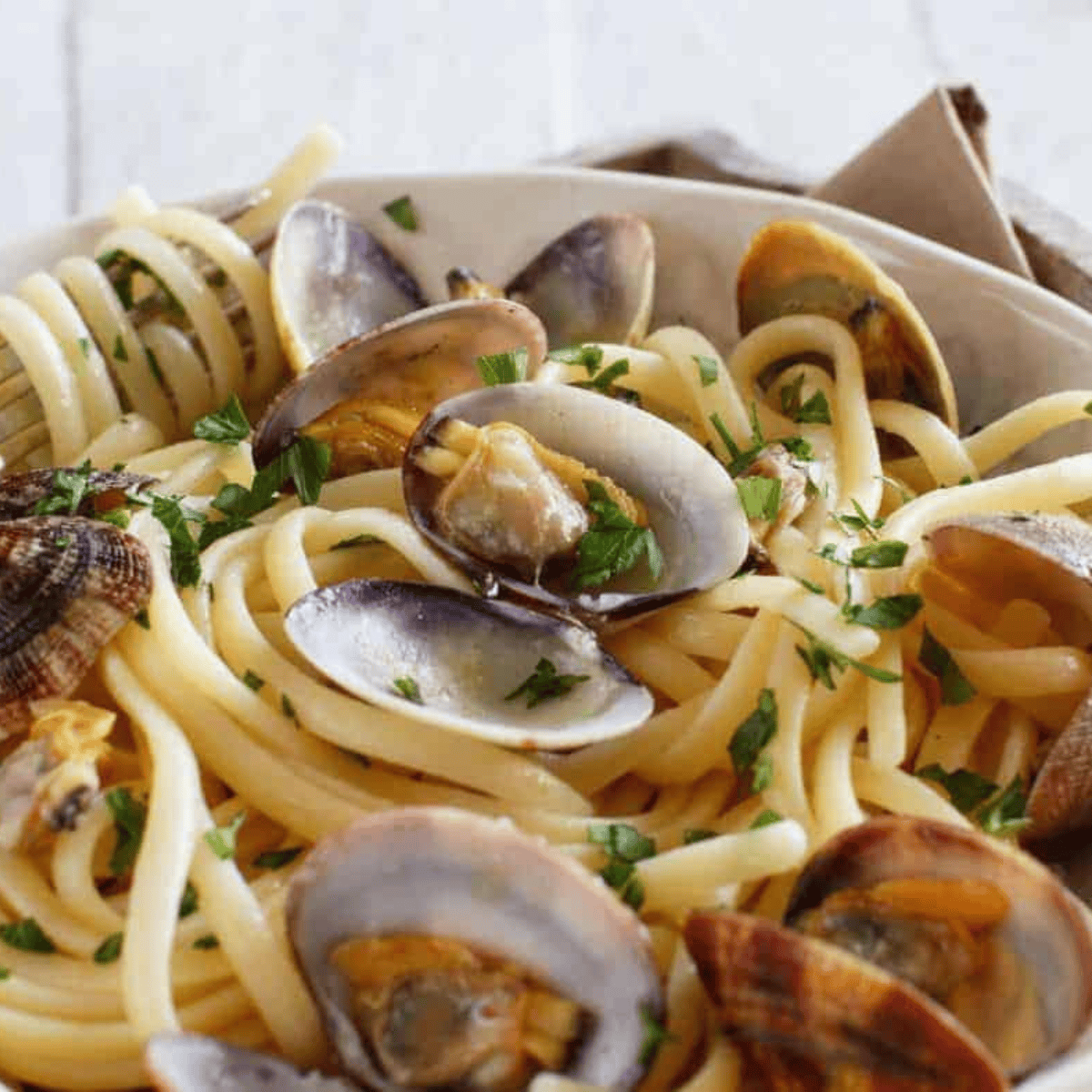 Tender, juicy clams cooked in the Instant Pot with garlic, butter, and white wine, served in a bowl ready to eat.