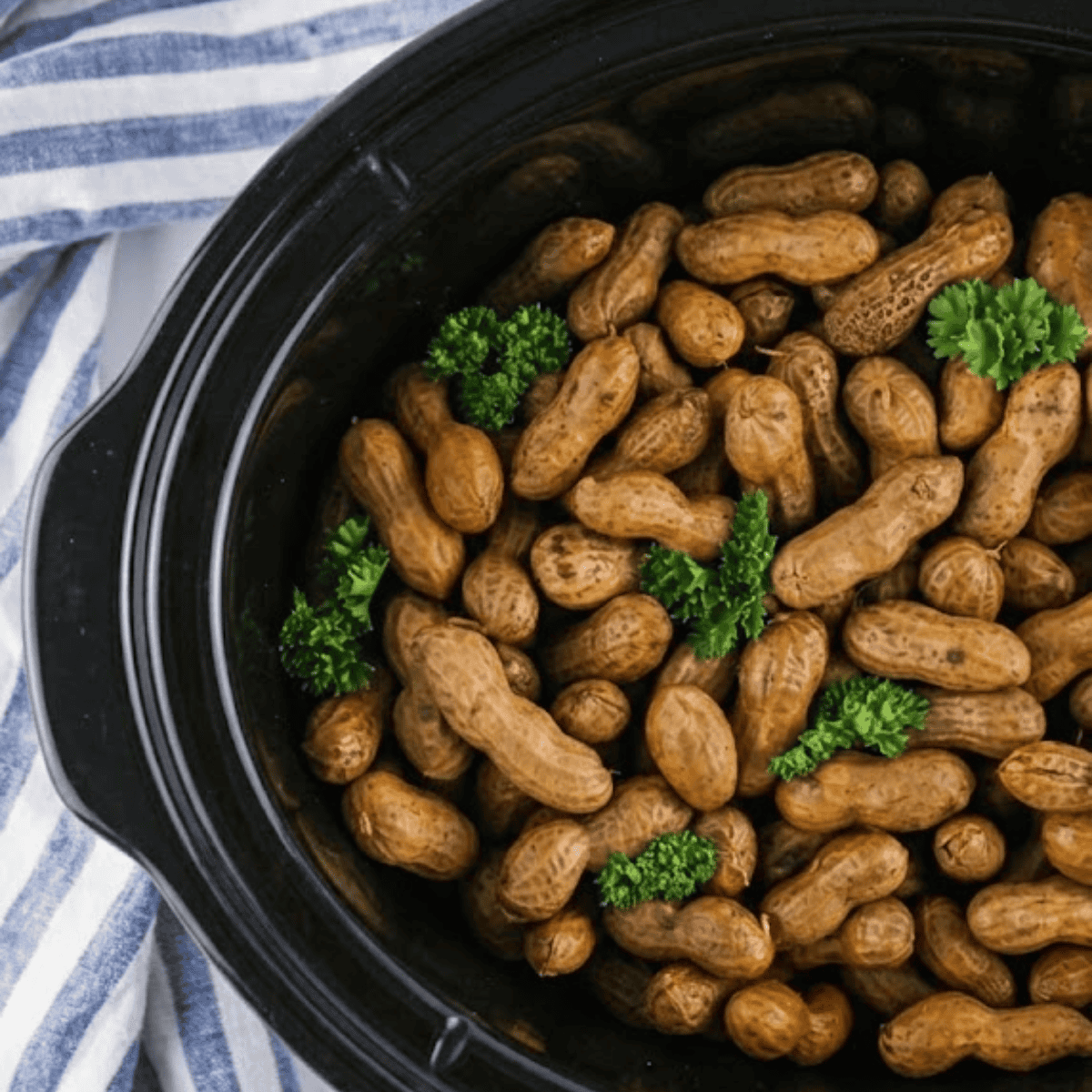 Crockpot Cajun boiled peanuts seasoned with spices and served warm in a bowl.