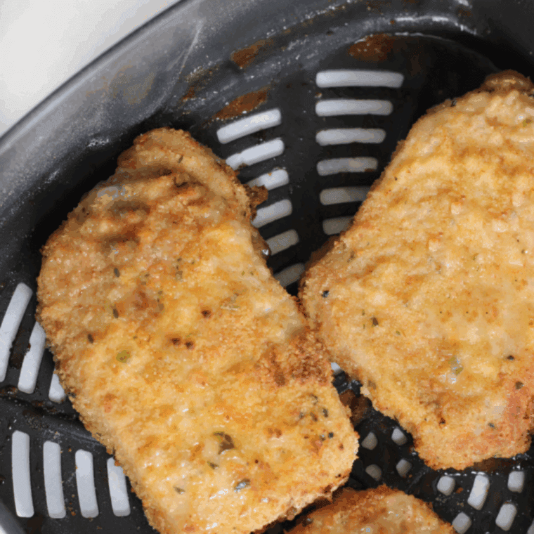 Golden crispy Shake ‘N Bake style pork chops cooking in the Ninja Foodi.