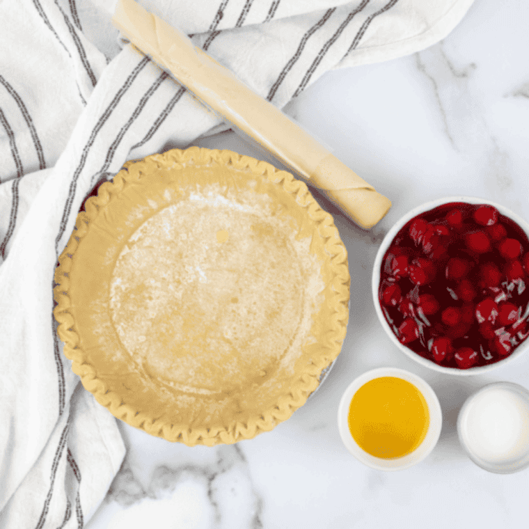 Air fryer cherry pie ingredients: frozen pie crusts, cherry pie filling, egg yolk, and milk