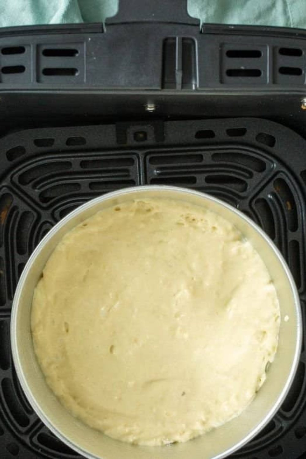 Pancake batter poured into small greased pan for air fryer cooking