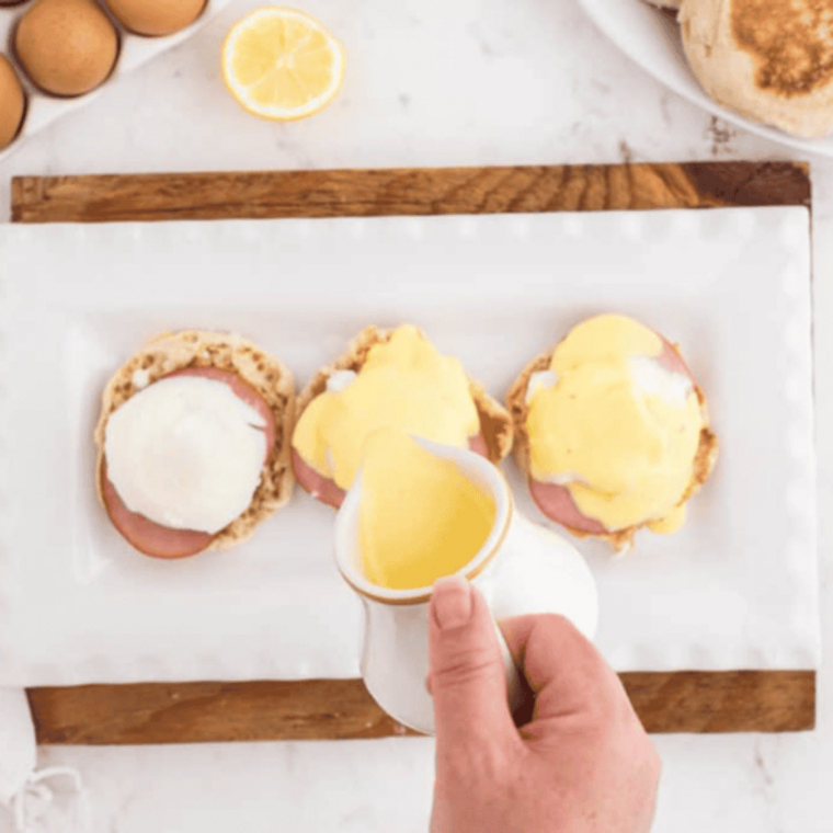 Eggs cooking in mini ramekins inside air fryer basket.