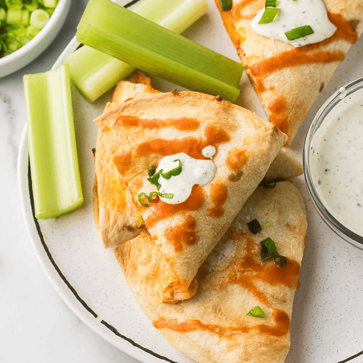 Slow cooker chicken quesadillas cut into golden wedges with melted cheese, served with guacamole and salsa