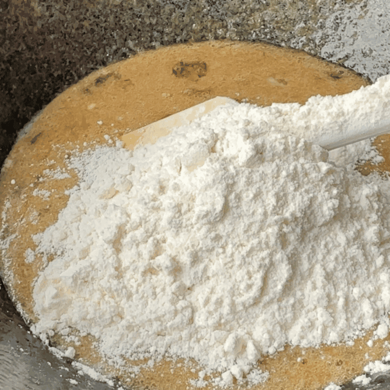 Mixing flour, sugar, cocoa, baking soda, and baking powder in a bowl