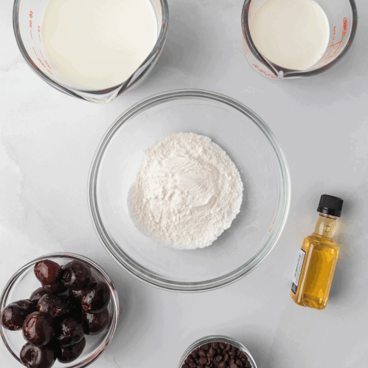 Ingredients for air fryer cherry cobbler: flour, sugar, baking powder, milk, butter, and cherry pie filling