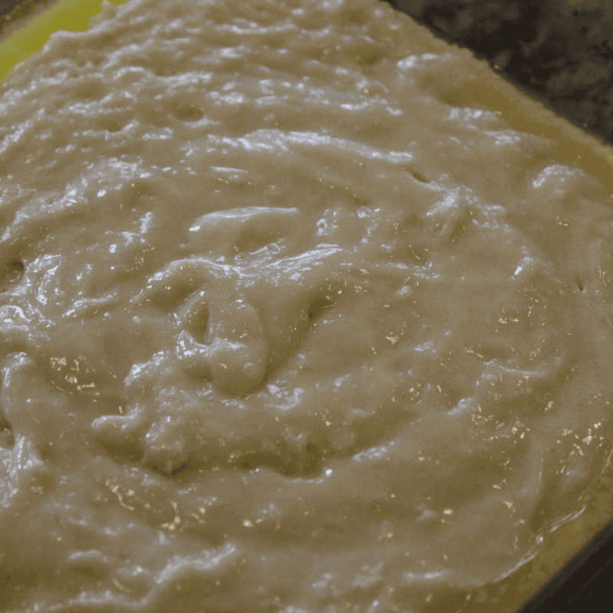 Cobbler batter poured over the melted butter in the pan