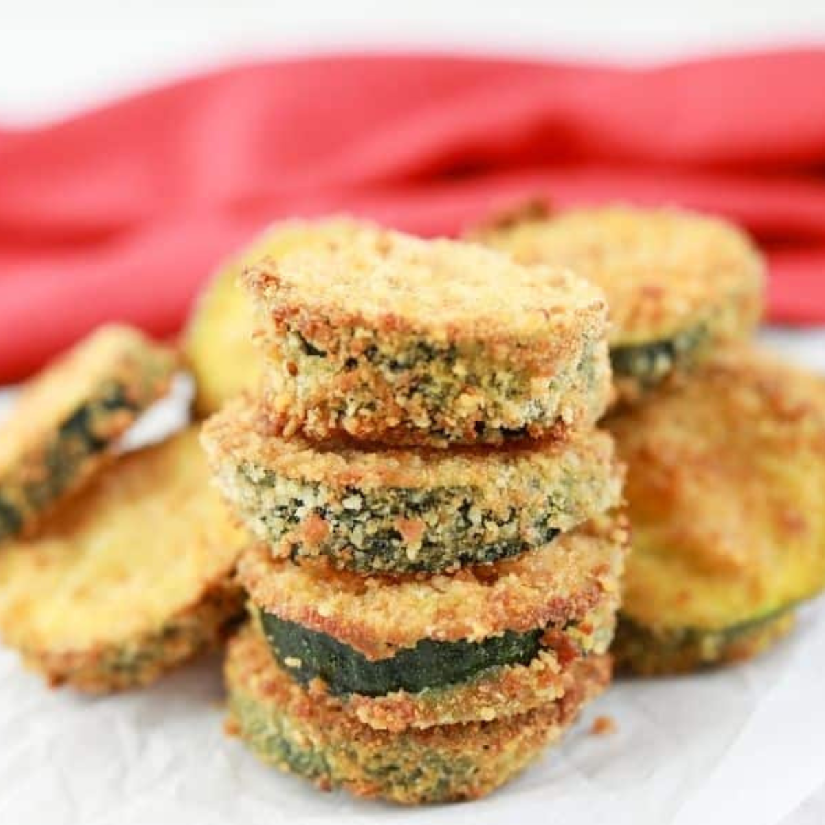 Crispy air fryer zucchini zircles coated and golden brown served with dipping sauce on a plate
