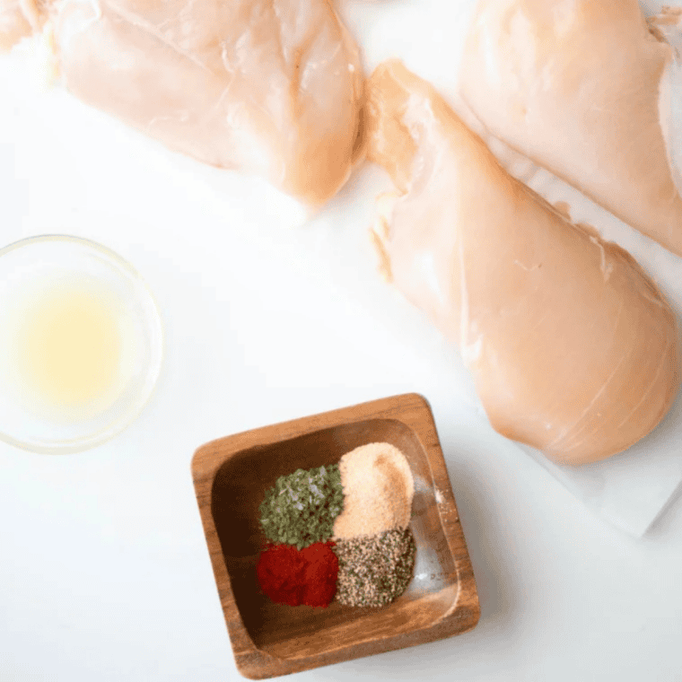 Ingredients for air fryer lemon pepper chicken: chicken breasts, olive oil, lemon pepper seasoning, garlic powder, and fresh lemon