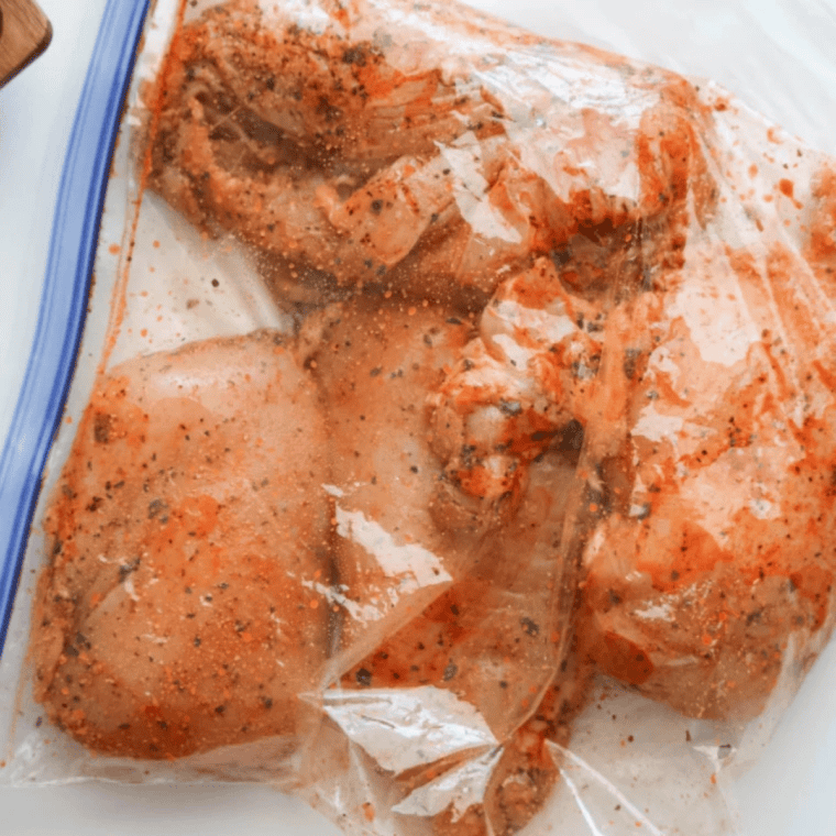 Seasoned chicken breasts arranged in a single layer in the air fryer basket