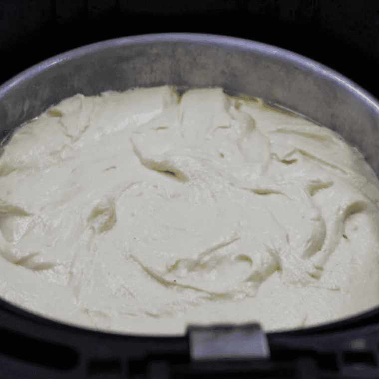 Ricotta cake batter in a 7-inch pan inside the air fryer basket