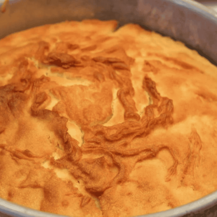 Baked lemon ricotta cake cooling and dusted with powdered sugar