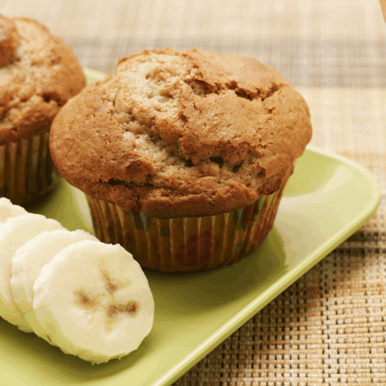 Freshly baked banana cardamom muffins cooling on a wire rack, golden brown with a soft, fluffy texture.