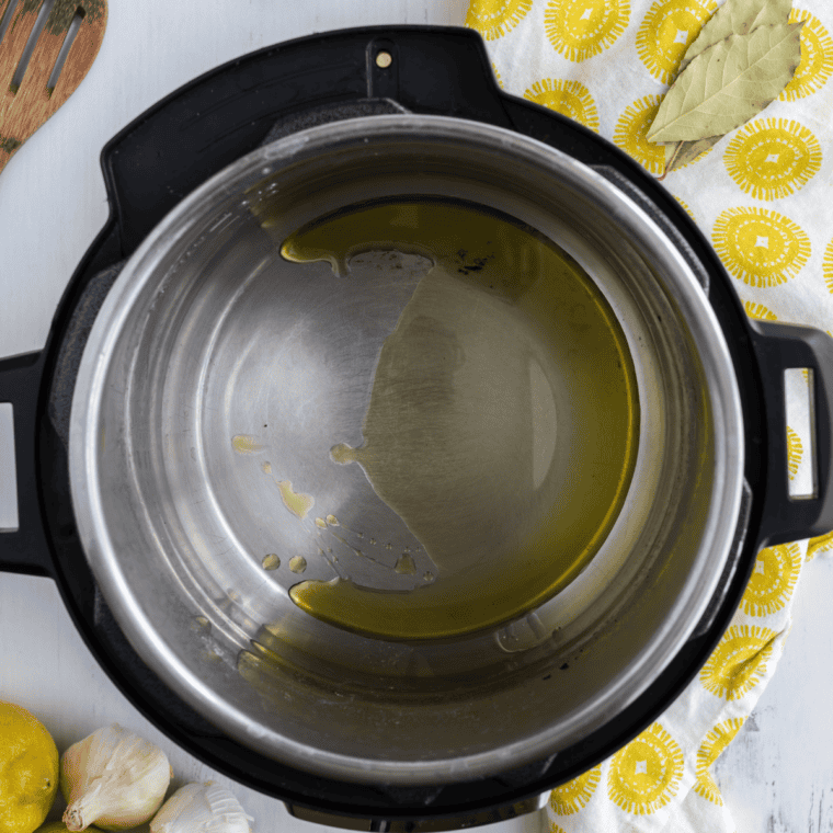 Diced chicken browning in olive oil in the Instant Pot on Sauté mode for Greek lemon chicken soup.