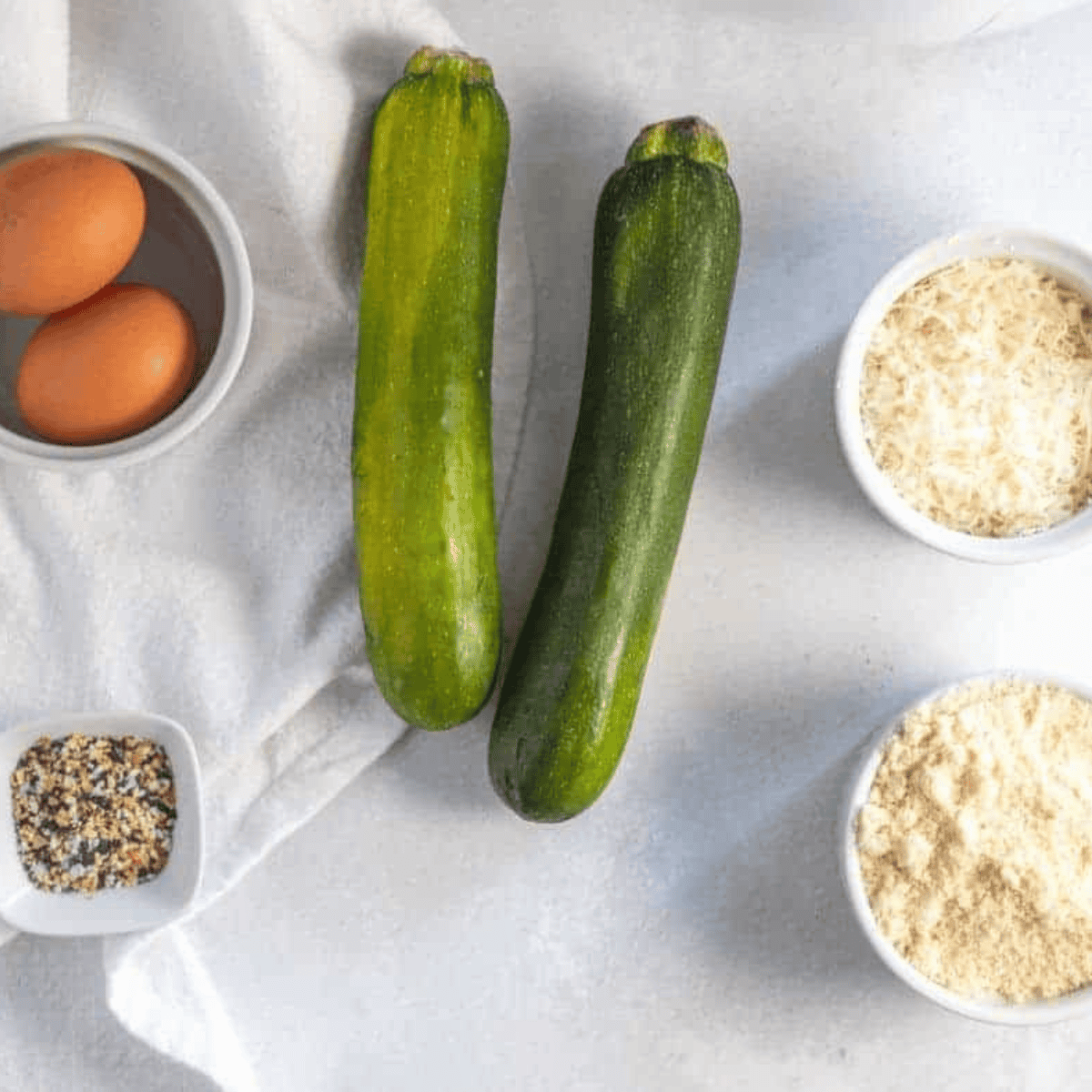 Ingredients needed for Easy Air Fryer Keto Zucchini Chips (Extra Crispy & Breaded) on kitchen table.