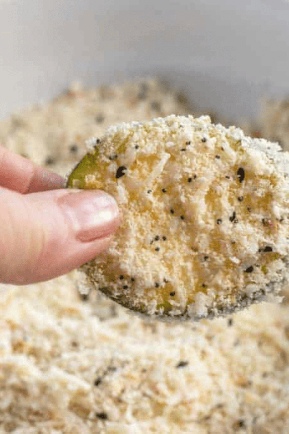 Zucchini slices being evenly coated with almond flour and grated Parmesan for crispy keto chips.