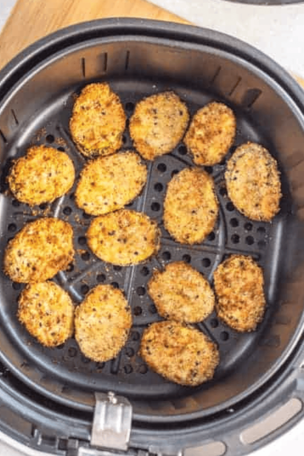 Remaining zucchini chips being air fried in batches until fully crispy and golden brown.
