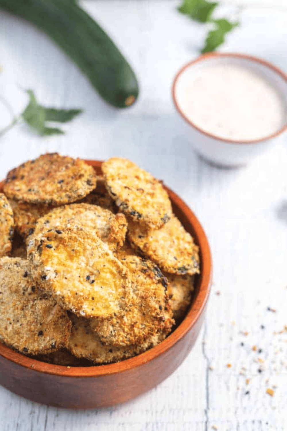 Extra crispy, breaded keto zucchini chips fresh from the air fryer on a serving plate.