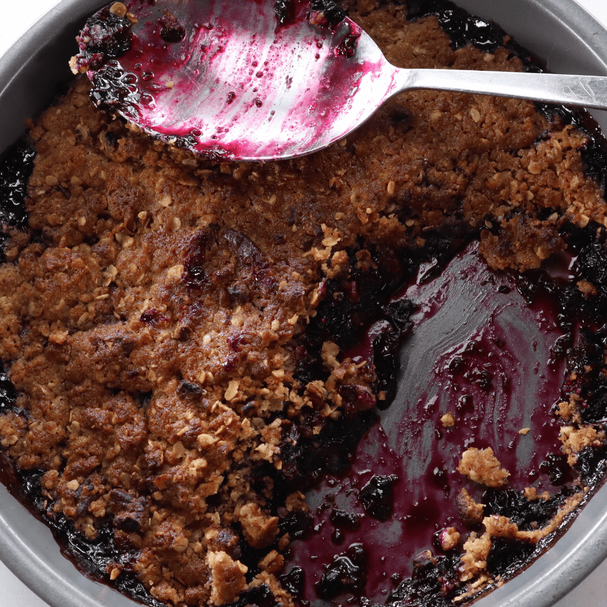 Warm air fryer blueberry crisp served in a bowl with a scoop of vanilla ice cream