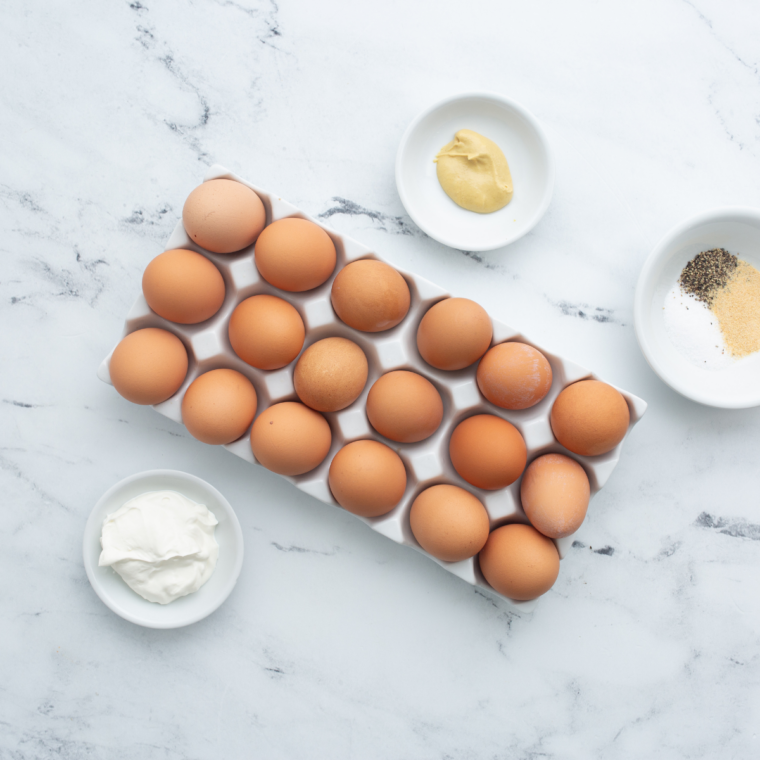 Ingredients for air fryer deviled eggs: eggs, mayonnaise, Dijon mustard, apple cider vinegar, salt, pepper, and paprika