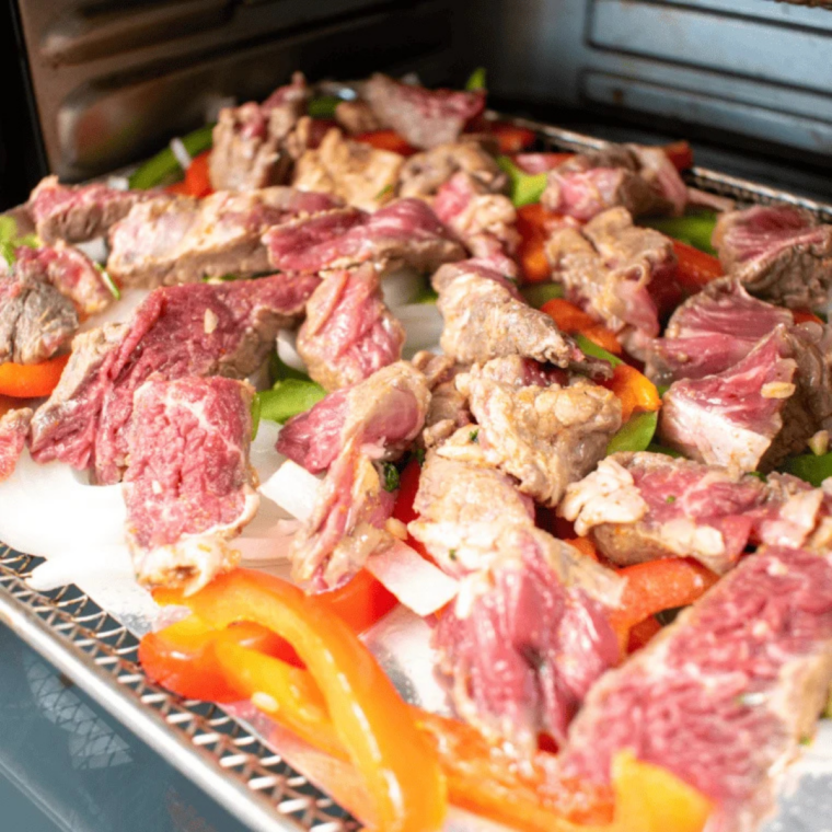 Marinated ribeye patted dry and arranged in a single layer in the air fryer basket