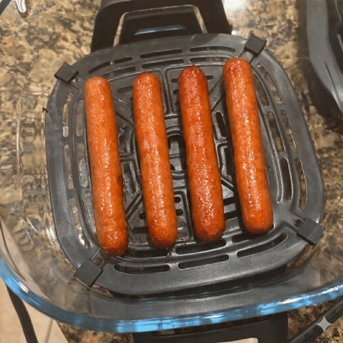 Hot dogs cooking in a Ninja air fryer basket with crispy browned edges, ready to serve in buns.