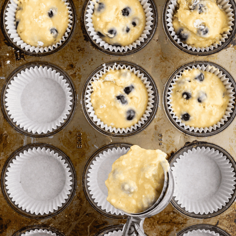 Muffin tin in air fryer baking muffins at 320°F, checking doneness with a toothpick