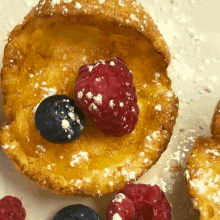 Small puffed mini Dutch pancakes baked in air fryer golden and dusted with powdered sugar