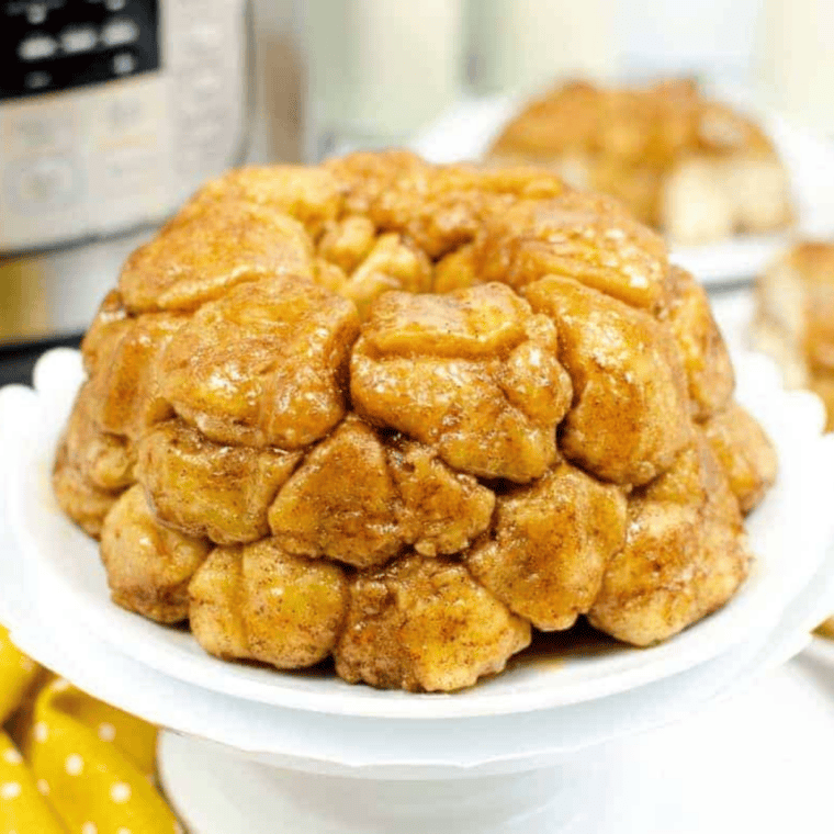 Air fryer monkey bread inverted onto a plate with warm caramel glaze spooned over the top