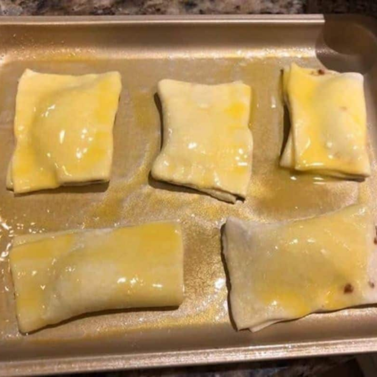 Nutella-filled puff pastry squares folded into triangles and crimped shut with a fork