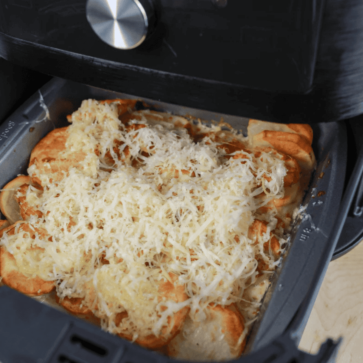 Cheese melting on Air Fryer Au Gratin Potatoes, ready to serve