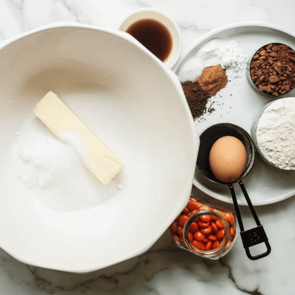 Mixing oatmeal chocolate chip cookie dough in a bowl with butter, sugars, eggs, oats, and flour.