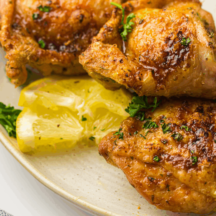 Crispy air fryer honey garlic chicken thighs coated in a sweet and savory sauce, ready to serve.