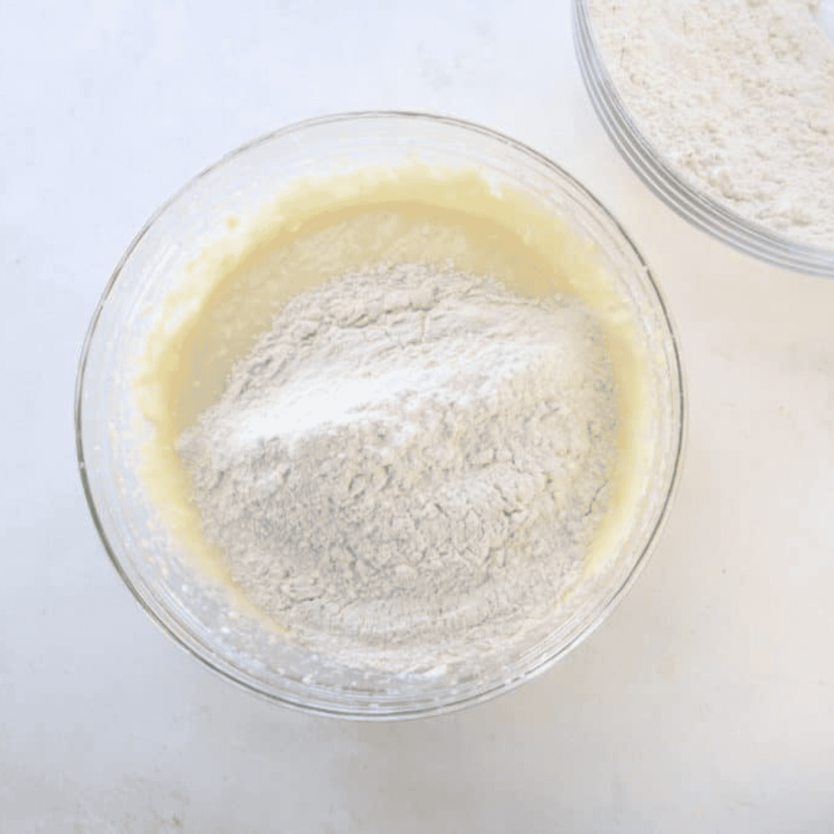 Large mixing bowl with cake mix, oil, and eggs being combined to form cookie dough.