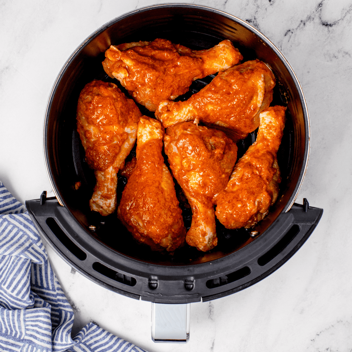 Place chicken drumsticks into the air fryer basket.