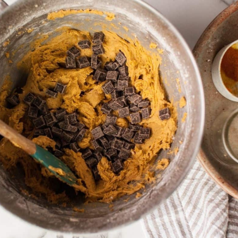 Pumpkin bread batter folded with chocolate chips in a mixing bowl