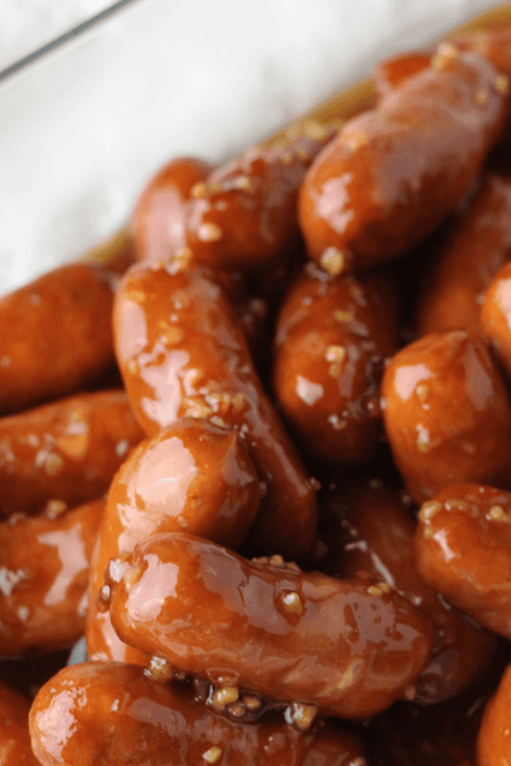 Air fryer little smokies coated in a glossy grape jelly sauce, served in a dish with toothpicks