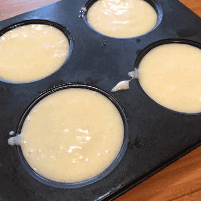 Smooth cheesecake filling being beaten in a mixing bowl with cream cheese, sugar, and eggs