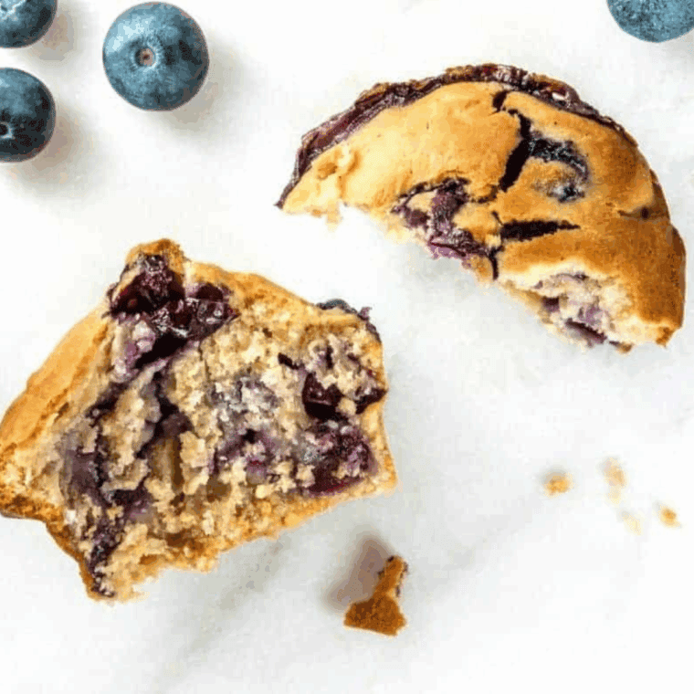 Single air fryer blueberry muffin with golden top and juicy blueberries, freshly baked and ready to enjoy.