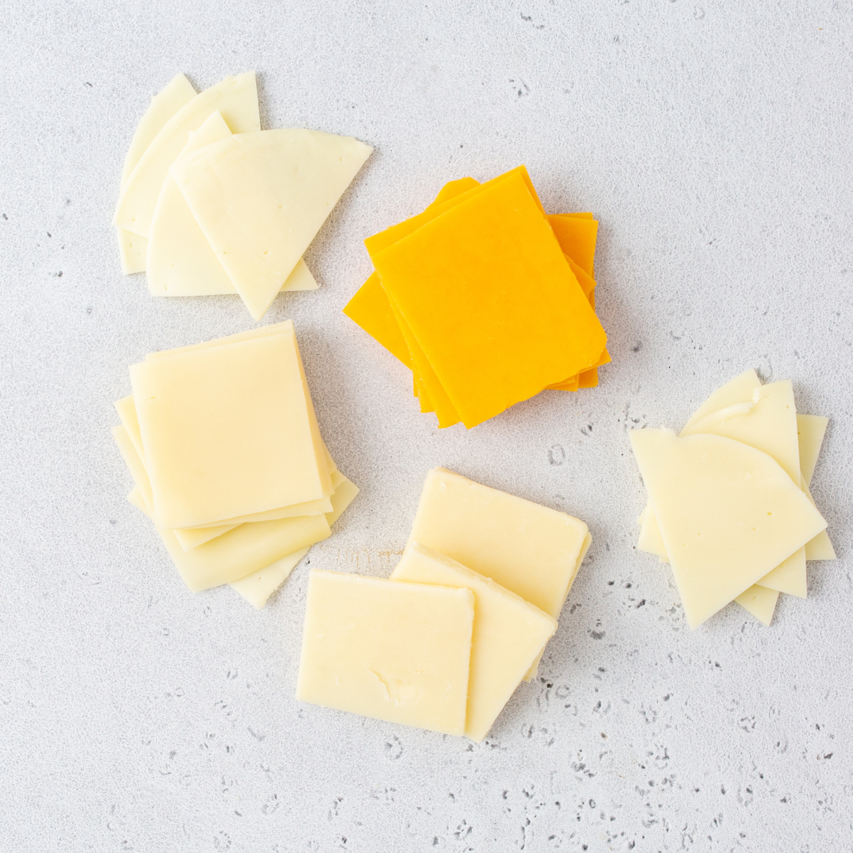 Ingredients for air fryer cheese crisps — ultra thin sliced cheddar cheese and parchment paper