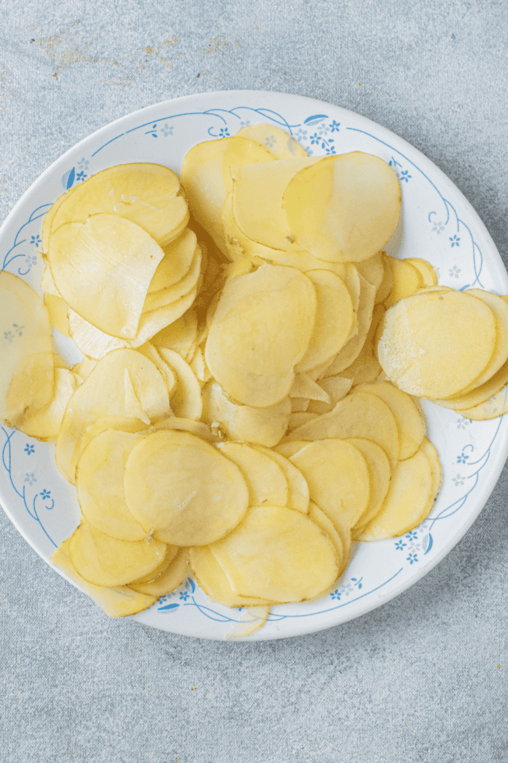 Thin potato slices cut with a mandoline soaking in cold water to remove starch.