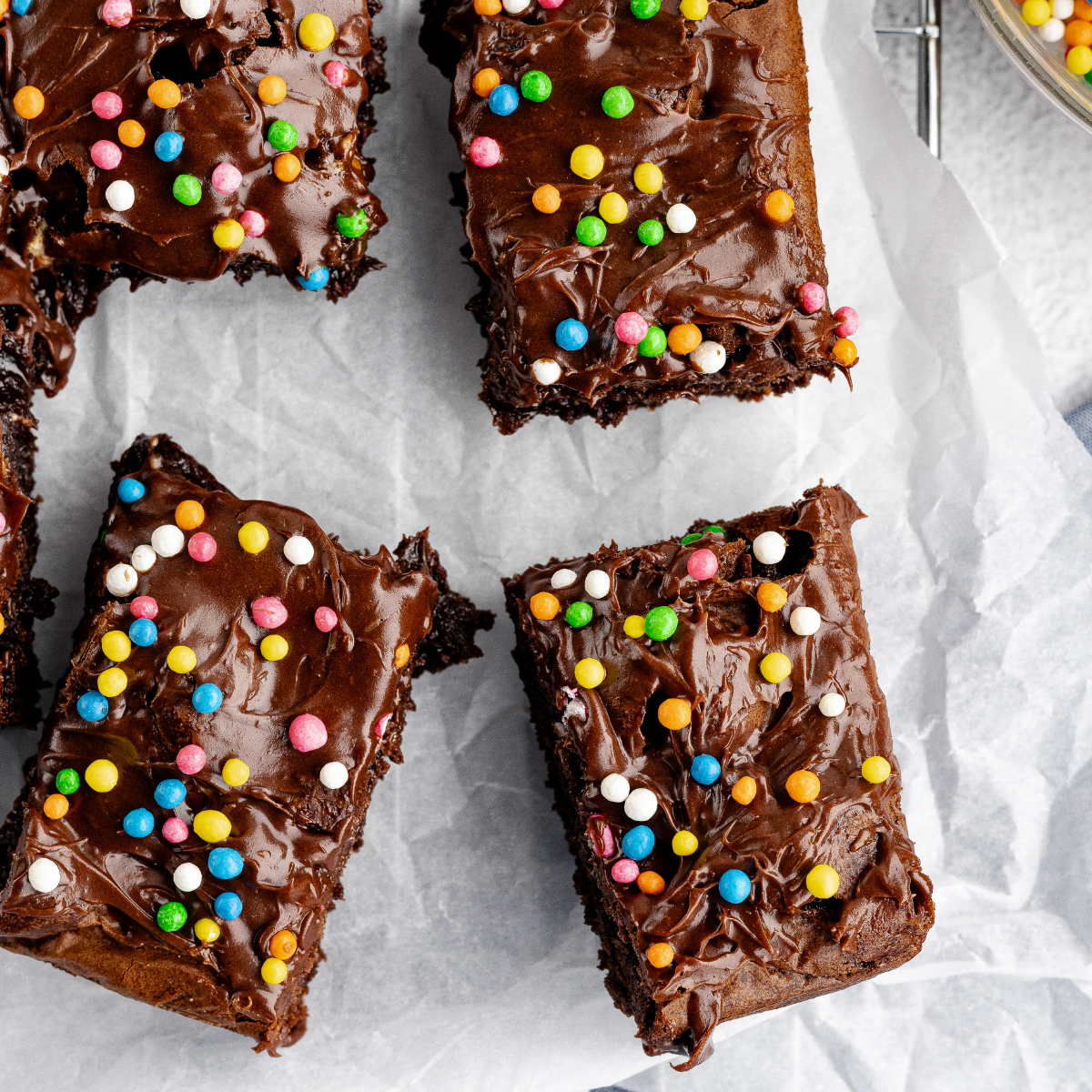 Plate of fudgy Ninja Crispi brownies topped with chocolate frosting and sparkles