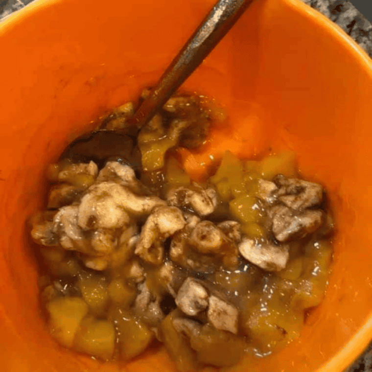 Peach pie filling slices diced into half-inch pieces on a cutting board