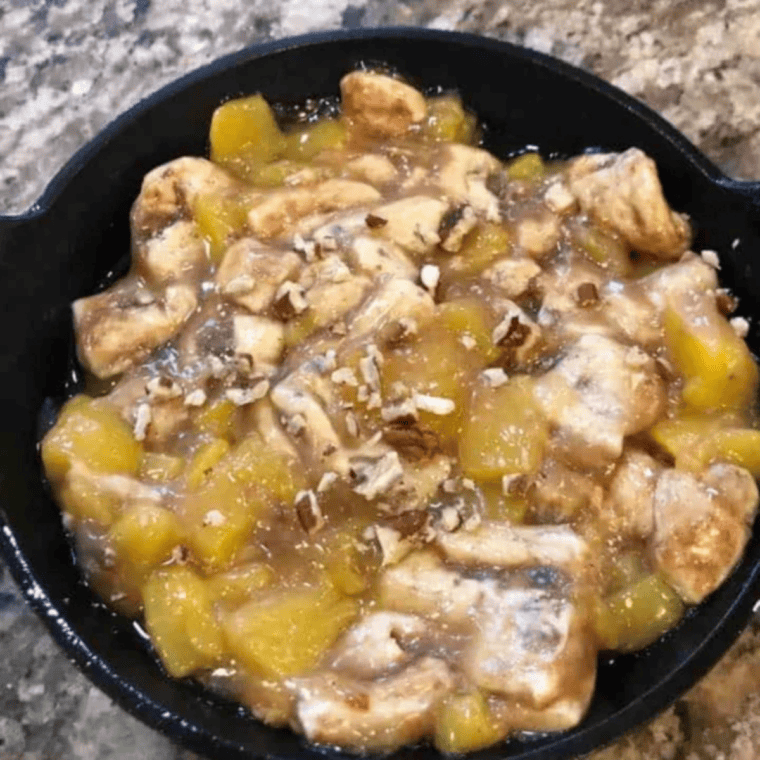 Cinnamon roll and peach mixture spread in an even layer in a greased round pan