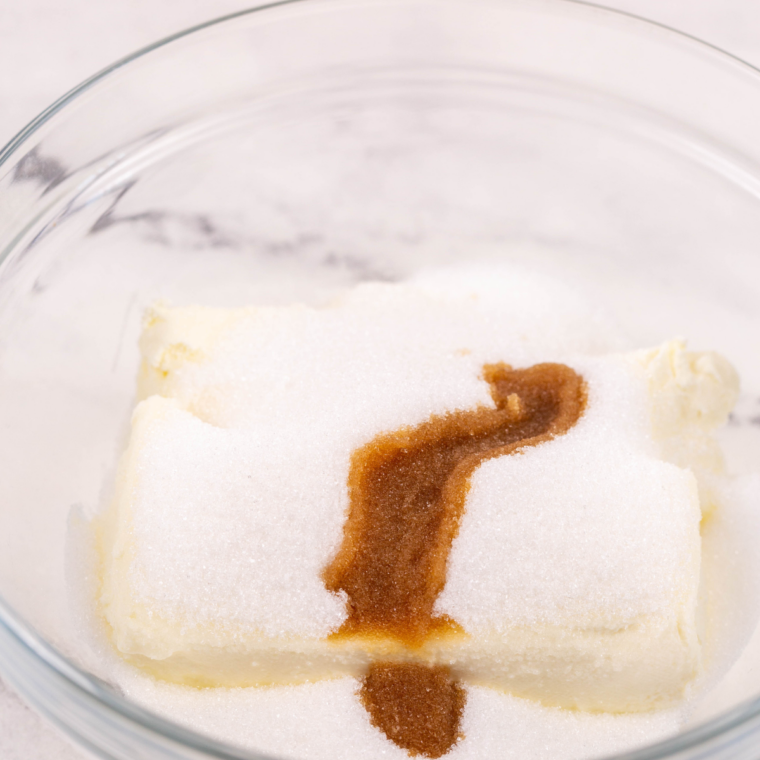 Cream cheese, sugar, and vanilla beaten smooth with a hand mixer in a glass mixing bowl