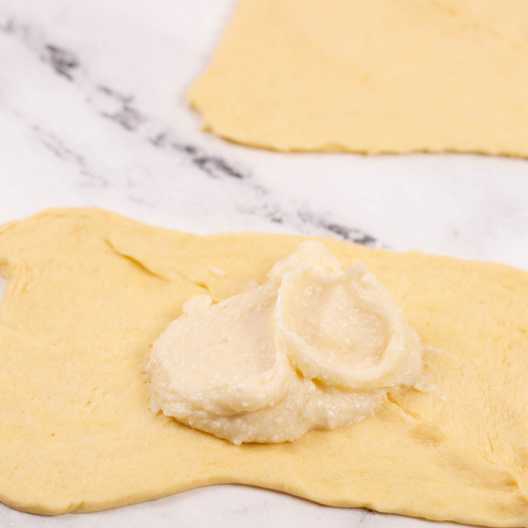 Two crescent roll triangles overlapped and pinched along the seam to form a rectangle