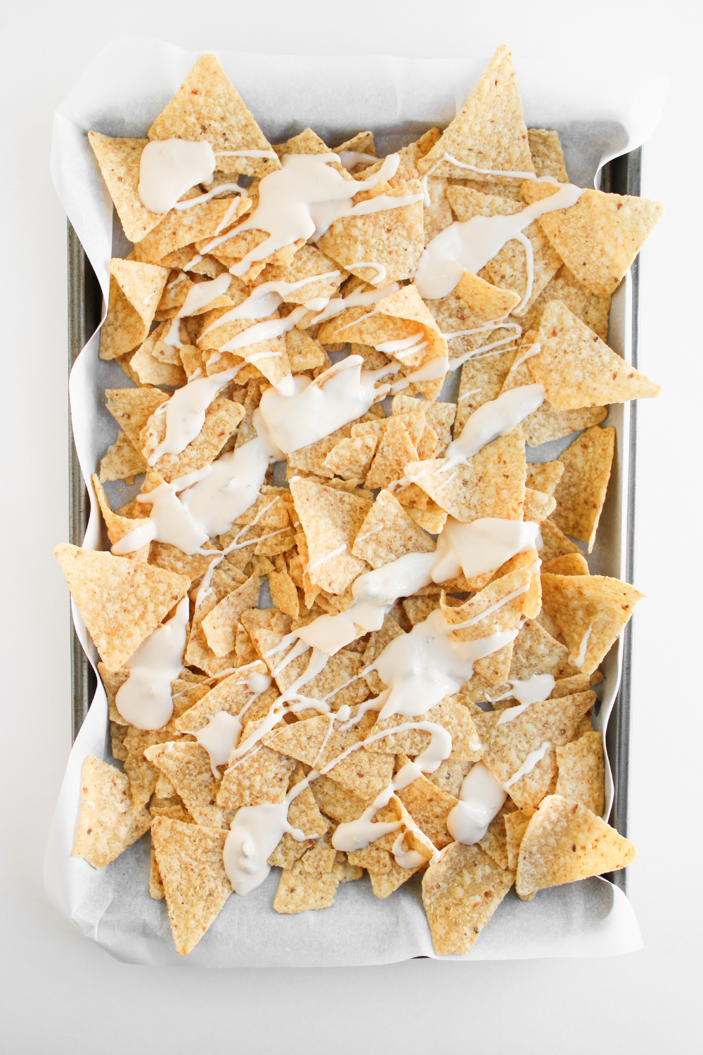 air fryer nachos layering tortilla chips cheese refried beans and seasoned beef evenly