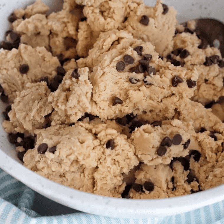 Oatmeal chocolate chip cookie dough poured into a greased cast-iron pan, ready for baking.
