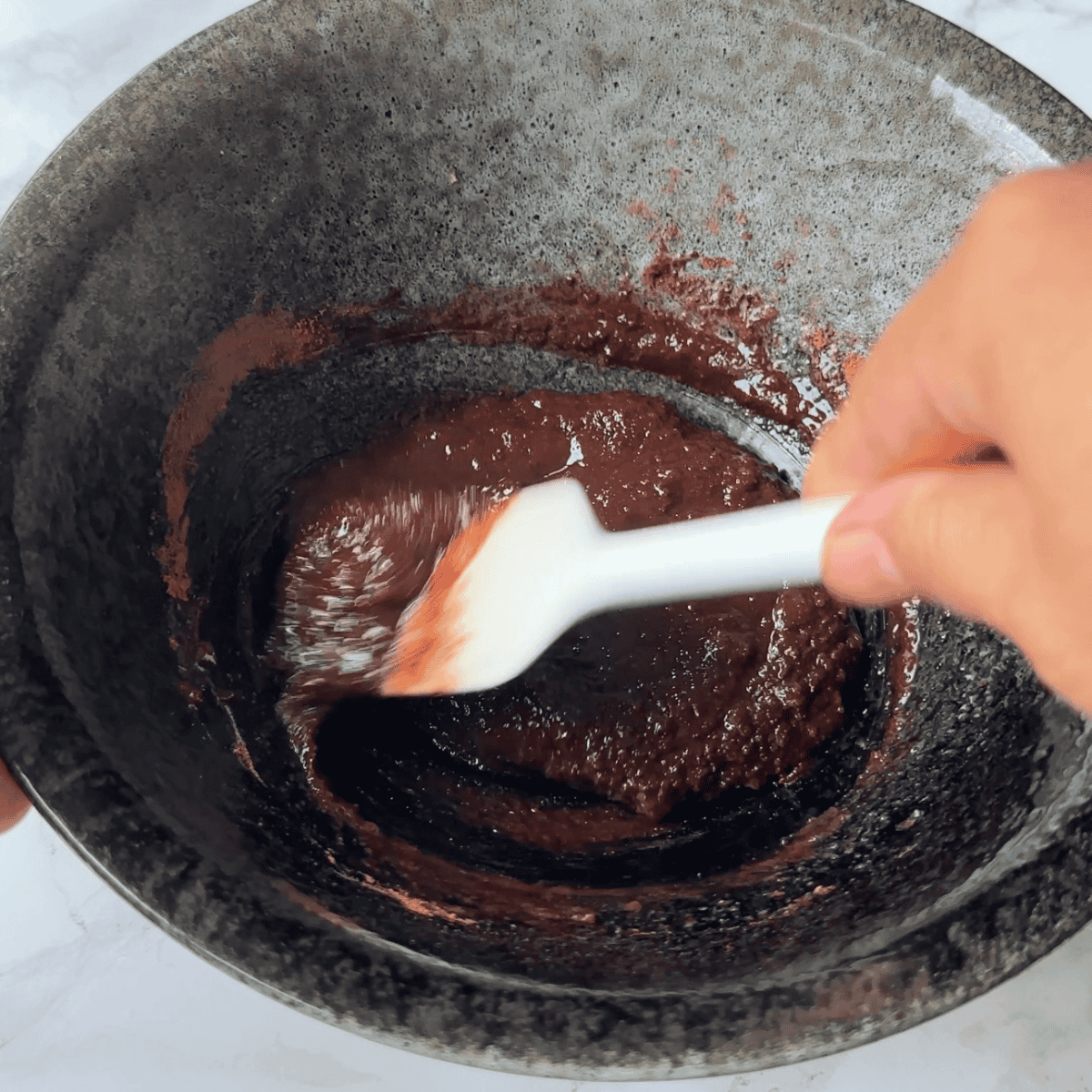 Mixing dry and wet ingredients to make chocolate marshmallow cookie batter